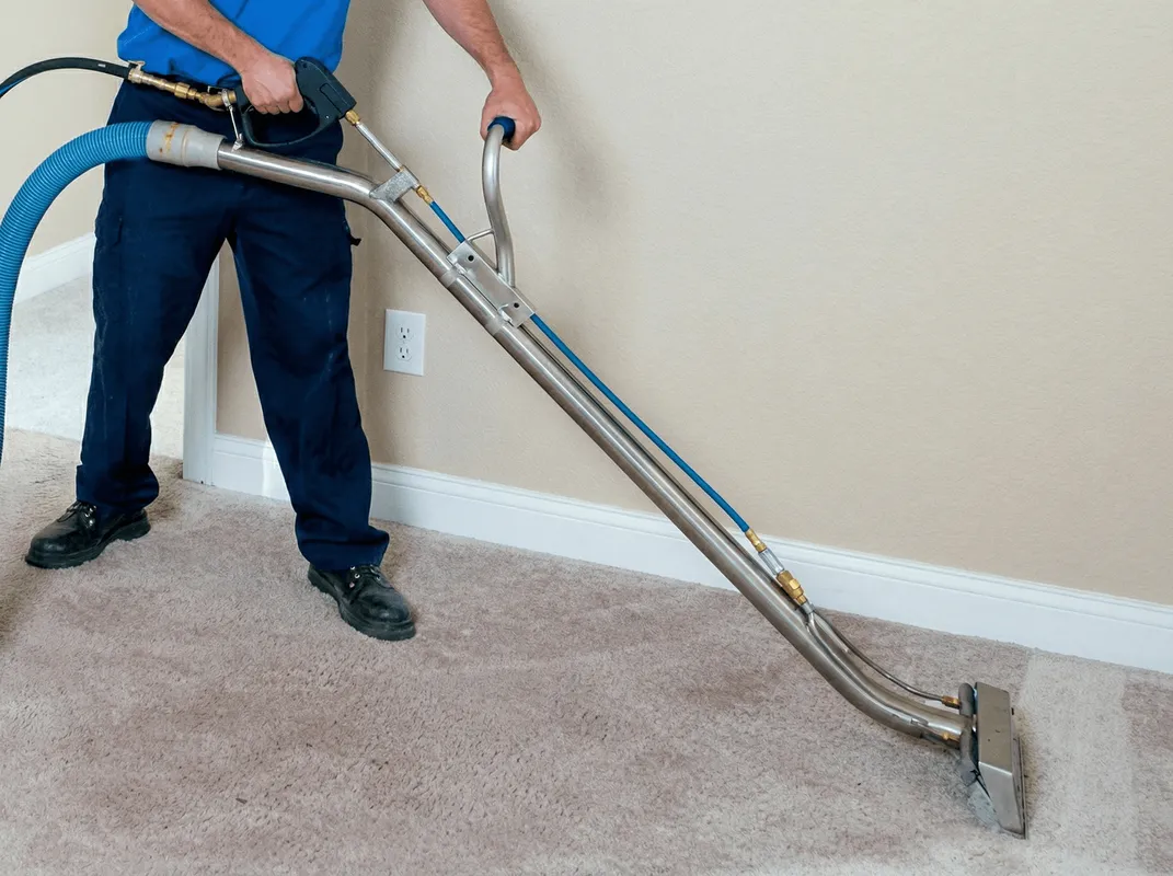 Professional operating a liquid removal machine on a carpeted floor in Reno, NV